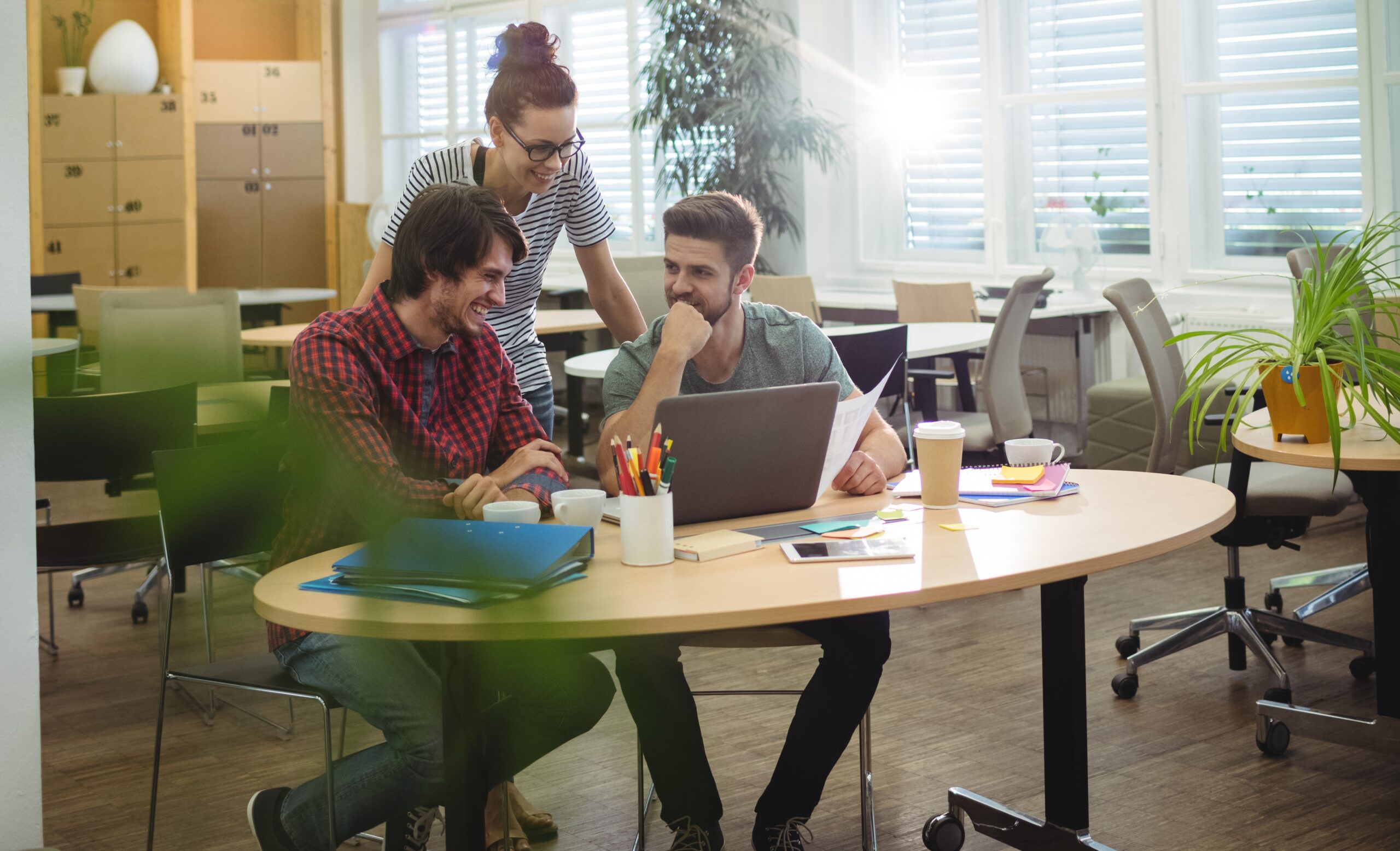 Group of business executives discussing over laptop at their desk