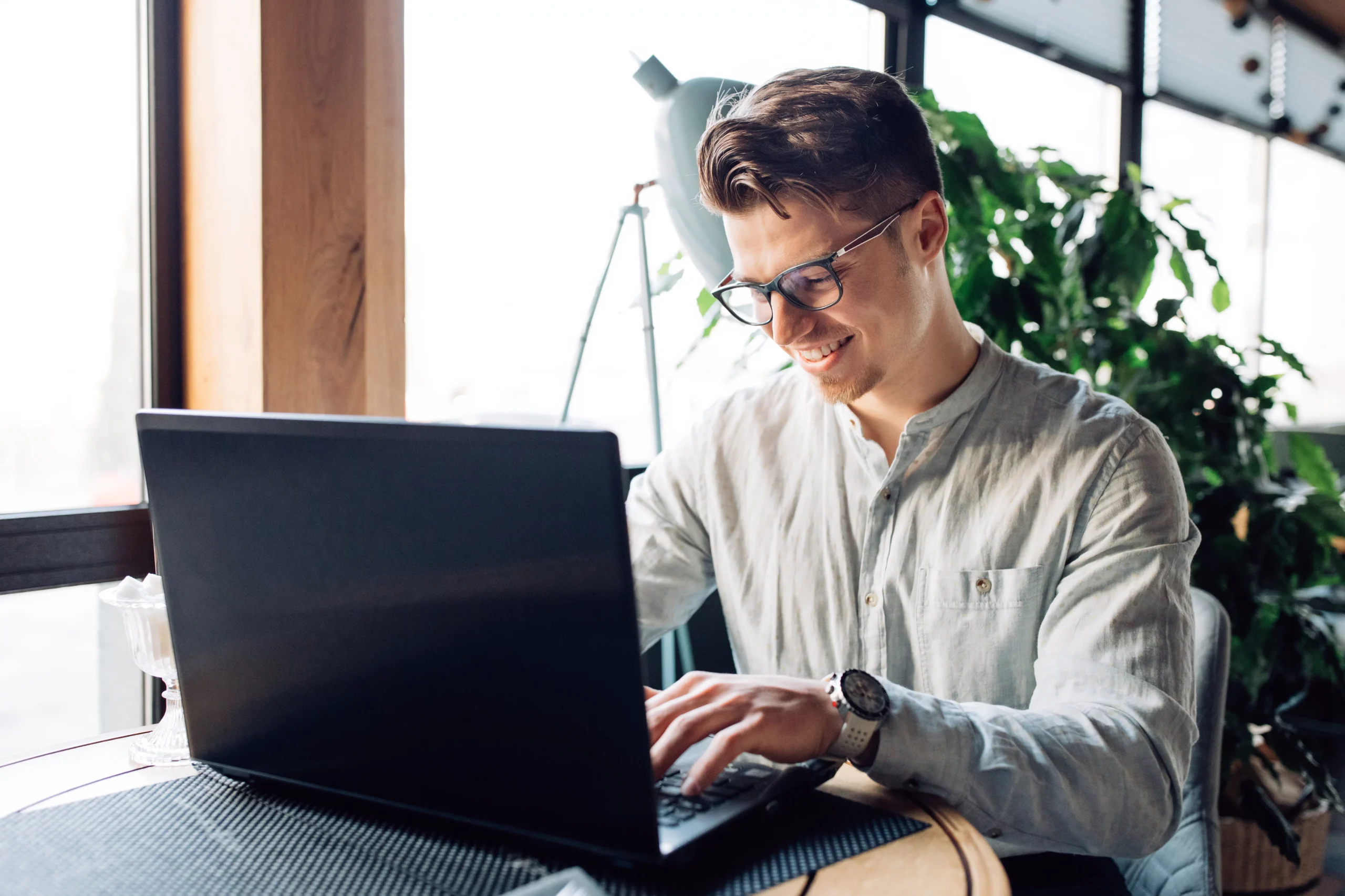 Mann mit Brille arbeitet am Laptop