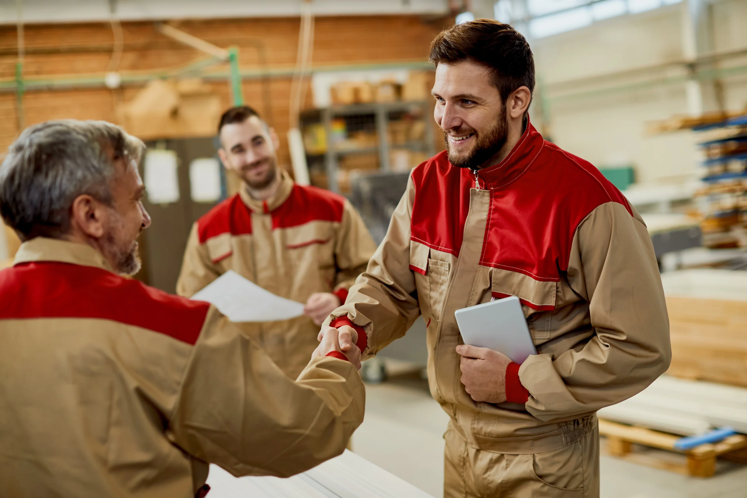 Arbeitskollegen in einer Werkstatt schütteln sich die Hände