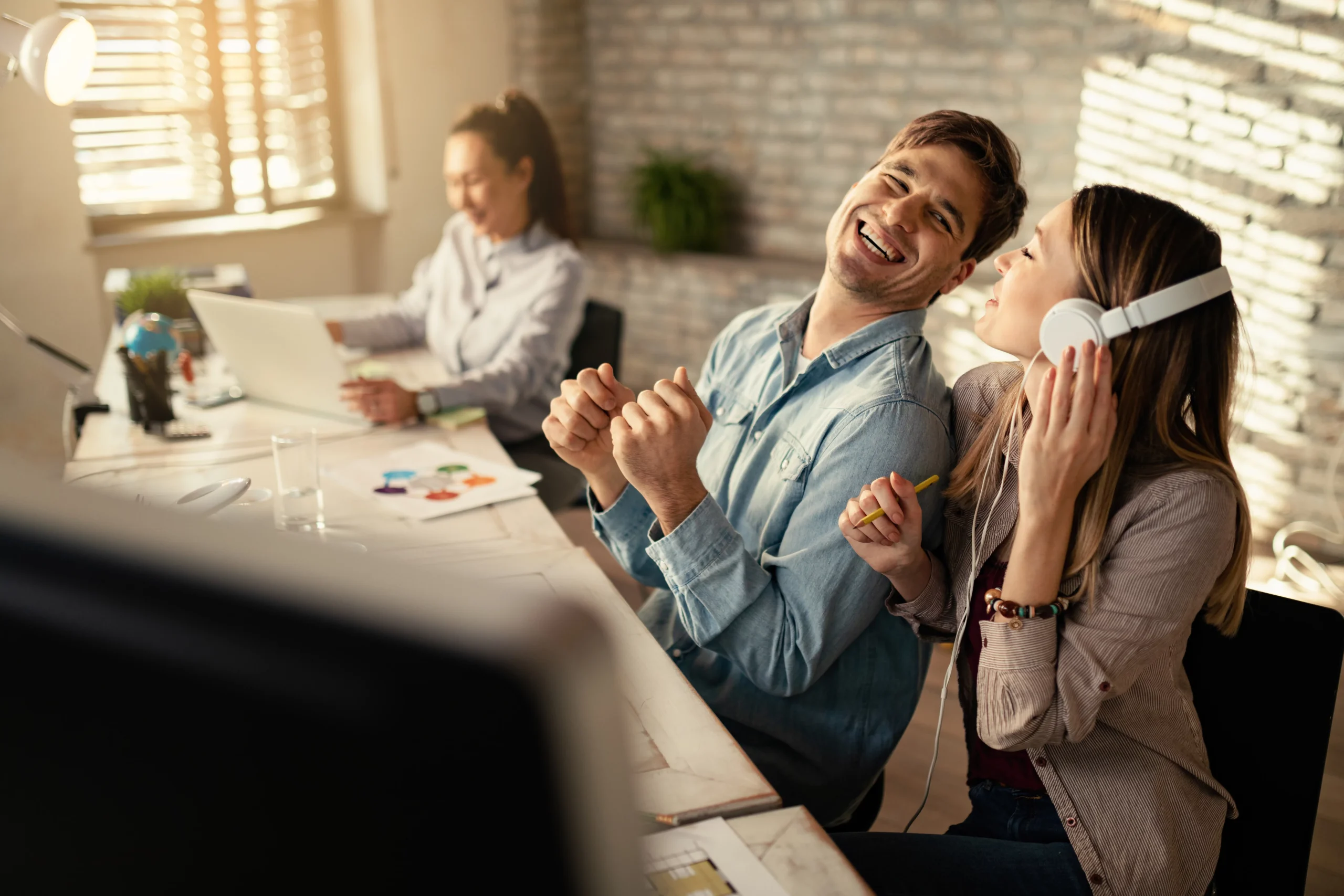 Kollegen lachen zusammen am Schreibtisch